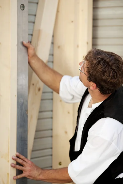 Carpenter measures with a water level — Stock Photo, Image