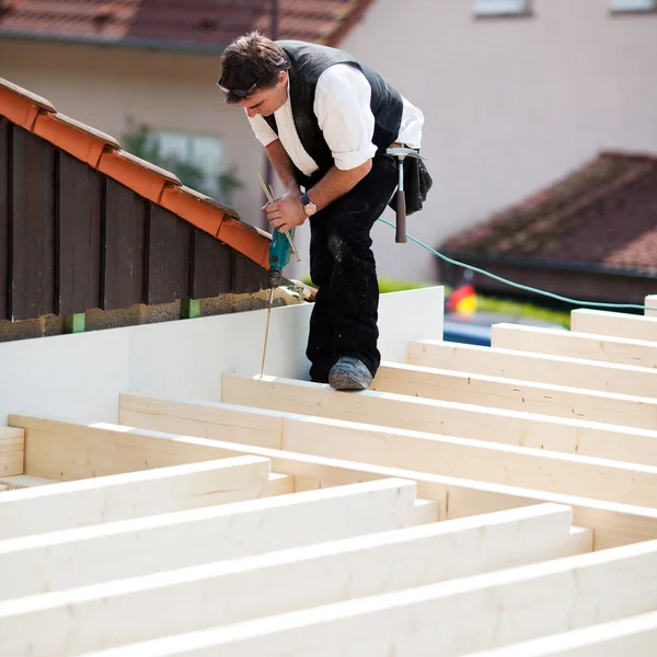 Carpinteiro que trabalha em um teto — Fotografia de Stock