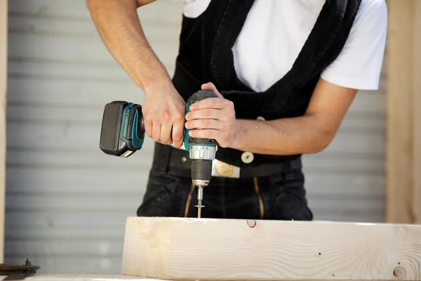 Carpenter drills a hole — Stock Photo, Image