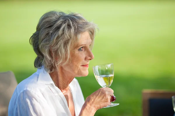 Äldre kvinna njuter av ett glas vin — Stockfoto