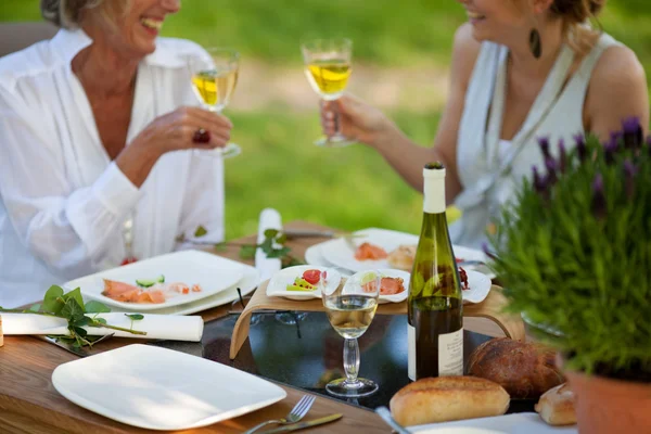 Duas mulheres dizendo aplausos na mesa de jantar — Fotografia de Stock