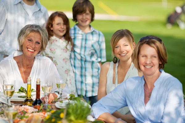 Familia feliz cenando en el jardín — Foto de Stock