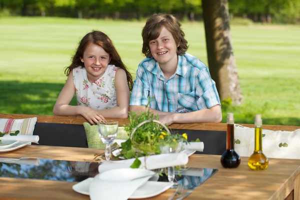 Frère et sœur penchés sur le banc de pelouse — Photo