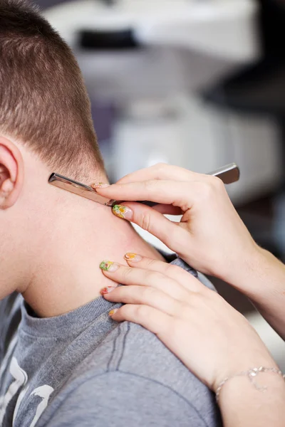 Hairdresser using razor in salon — Stock Photo, Image