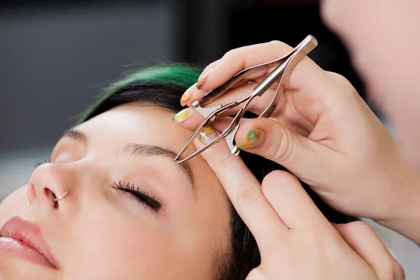 Penata rambut Tangan Menggunakan Tweezers On Womans Eyebrow — Stok Foto