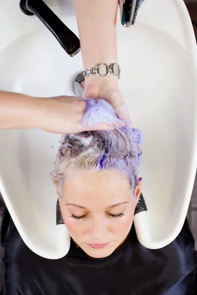 Mulher recebendo cabelo lavado no salão de cabeleireiro — Fotografia de Stock