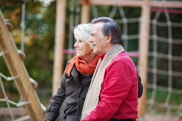 Senior couple sitting on a playground — Stock Photo, Image