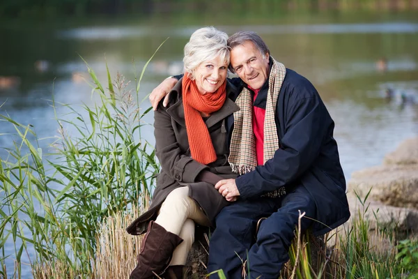 Un couple âgé posant au bord du lac — Photo