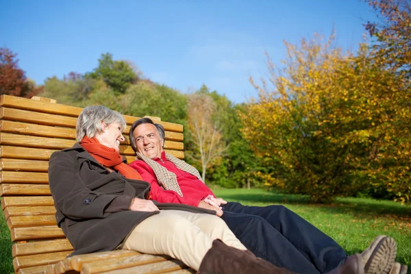 Pareja mayor relajándose bajo el sol de otoño —  Fotos de Stock