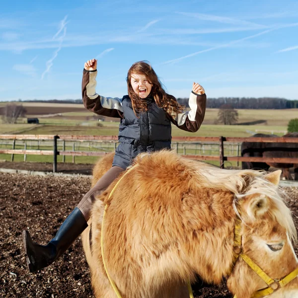 Девушка выражает счастье во время езды на лошади — стоковое фото