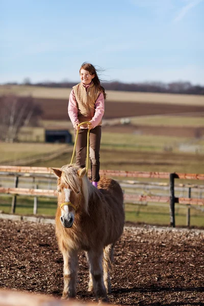 Dívka provádí akrobacie na koni — Stock fotografie