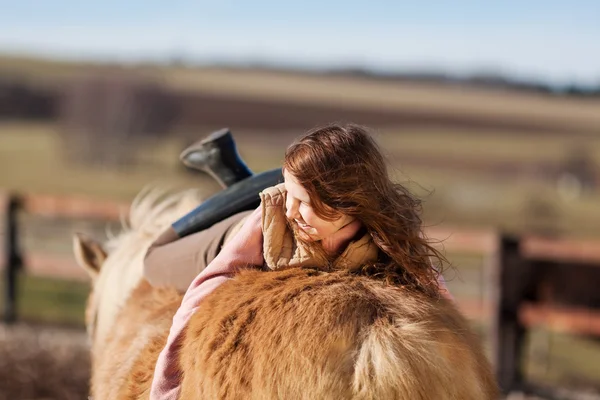 Retrato de uma menina deitada em seu cavalo — Fotografia de Stock