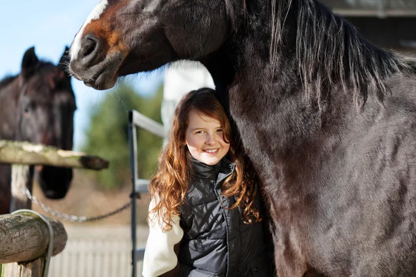 Young happy girl with her dark bay horse — Stock Photo, Image