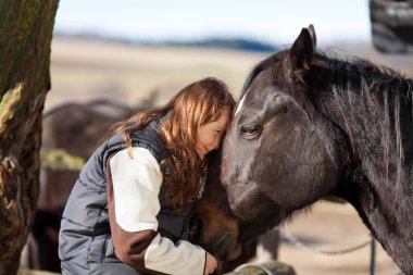 Young girl petting her horse clipart