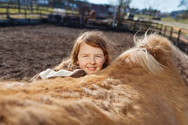 Игривая молодая девушка, оглядывающаяся на лошадь — стоковое фото