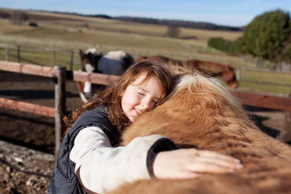 Young girl petting her horse — Stok fotoğraf