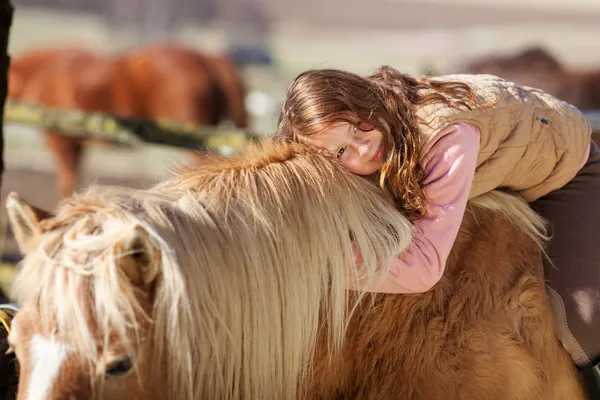 Porträt eines jungen Mädchens, das auf einem Pferd liegt — Stockfoto