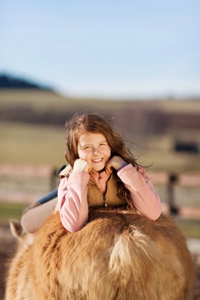 Porträt eines Mädchens, das auf ihrem Pferd liegt — Stockfoto