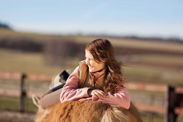 Portrait of a girl laying on her horse — Stock Photo, Image