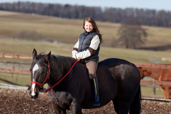 Retrato de una joven montando su oscuro caballo de la bahía — Foto de Stock
