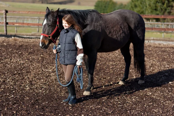 Hübsches Mädchen führt ihr Pferd — Stockfoto