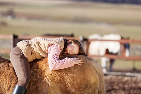 Giocoso giovane ragazza posa nel suo cavallo — Foto Stock