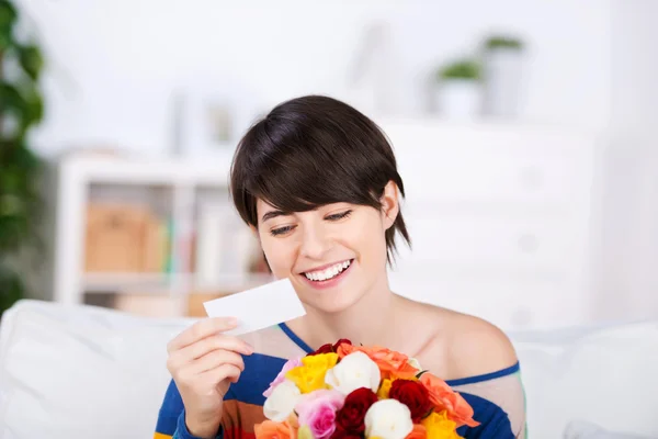 Mooie vrouw met een geschenk van bloemen — Stockfoto