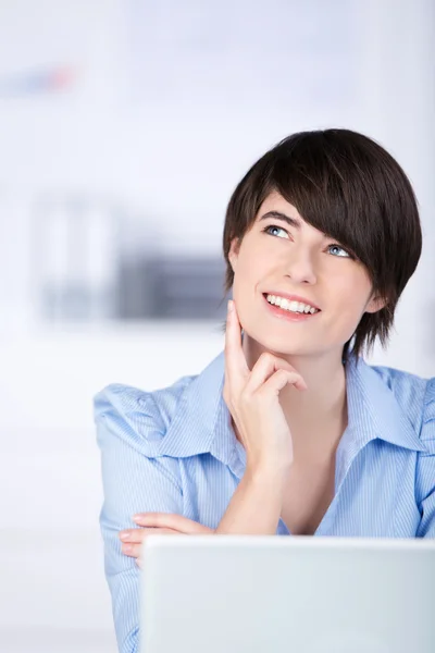 Smiling businesswoman sitting thinking — Stock Photo, Image