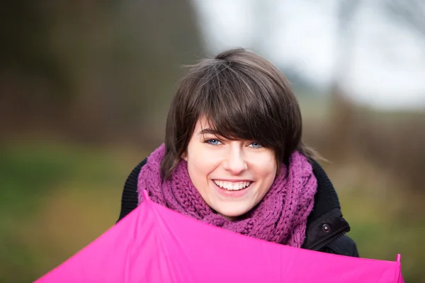 Smiling girl closing umbrella — Stock Photo, Image