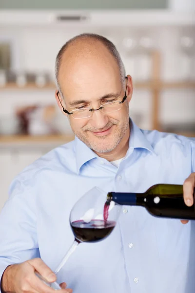 Nalít červené víno do sklenice — Stock fotografie
