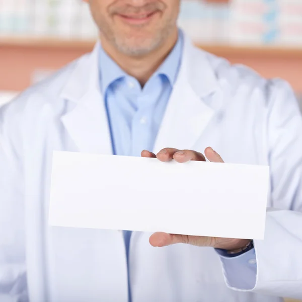 Smiling pharmacist with white paper — Stock Photo, Image