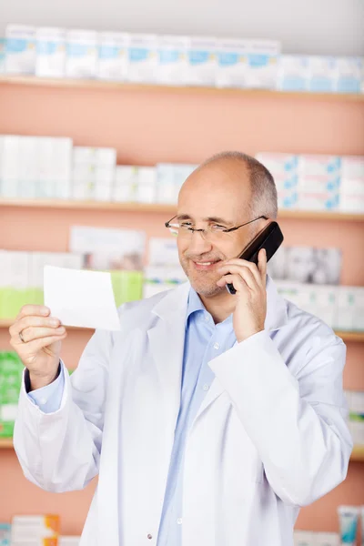 Mature pharmacist with phone — Stock Photo, Image