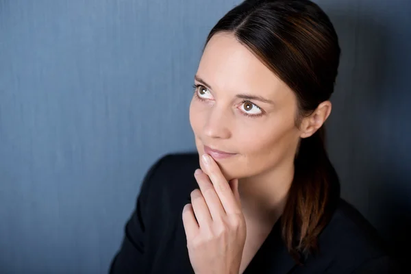 Thoughtful Businesswoman Looking Up Against Blue Wall — Stock Photo, Image