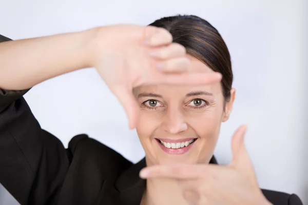 Mujer de negocios mirando a través del marco de la mano — Foto de Stock