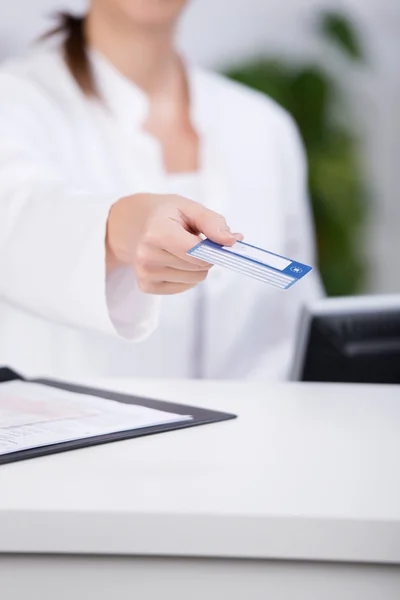 Recepcionista dando cartão de crédito no balcão no hospital — Fotografia de Stock