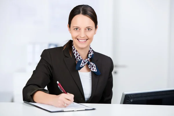 Receptionist Signing Check On Clipboard At Reception — Stock Photo, Image