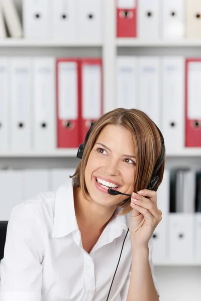 Mujer de negocios sonriente hablando en auriculares — Foto de Stock