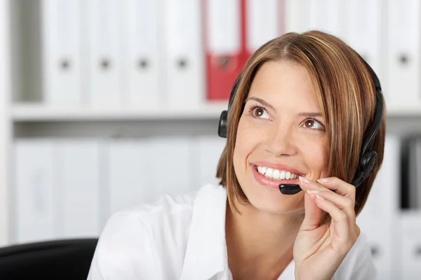 Mujer de negocios positiva hablando en auriculares — Foto de Stock