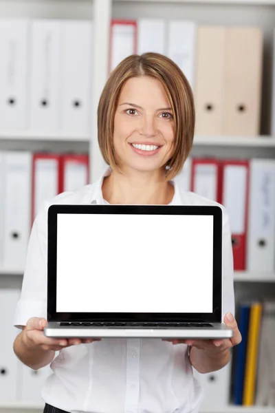 Sorrindo jovem mulher mostrando seu laptop — Fotografia de Stock