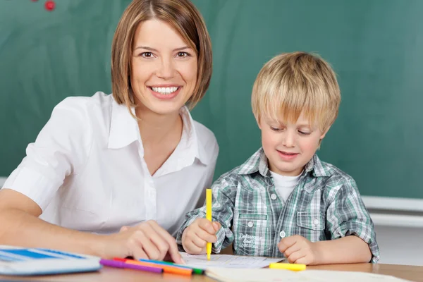 Educador sorridente com menino — Fotografia de Stock