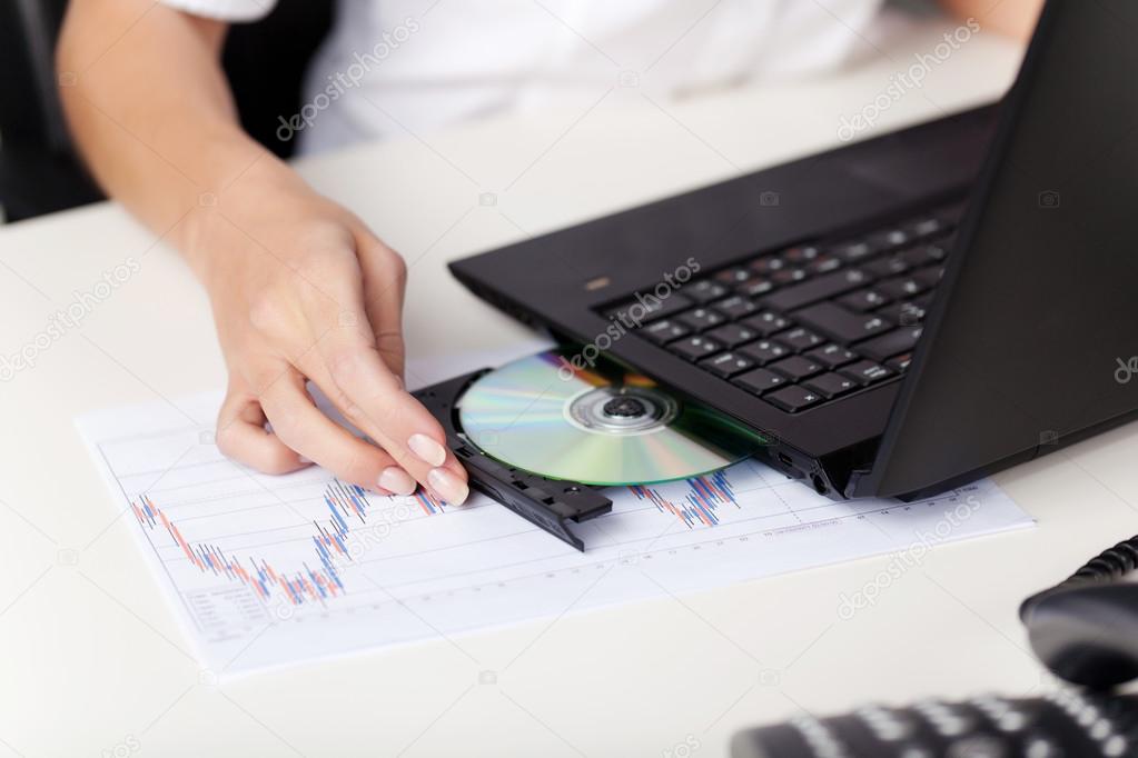 Woman Inserting A Cd In Her Laptop Stock Photo C Racorn 26440217