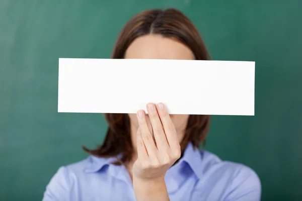 Teacher Holding Blank Paper Against Chalkboard — Stock Photo, Image