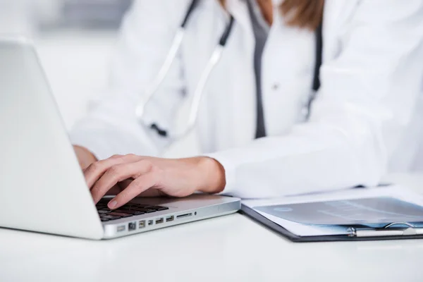 Médico feminino usando laptop na mesa — Fotografia de Stock