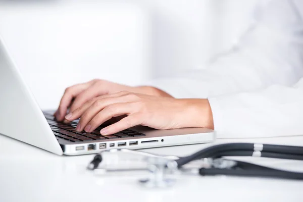 Arzthände mit Laptop am Schreibtisch — Stockfoto