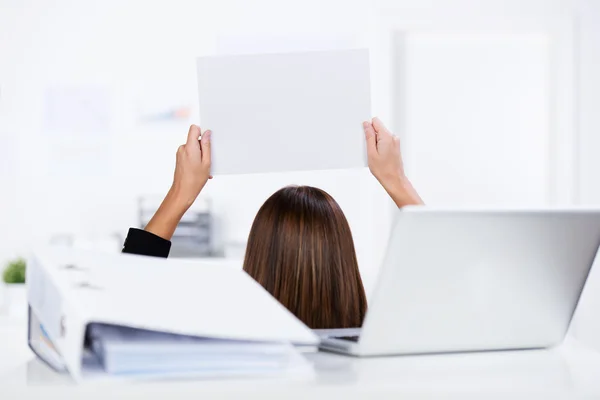Geschäftsfrau hält leeres Papier mit Ordner und Laptop auf Schreibtisch — Stockfoto