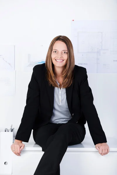 Confident Businesswoman Sitting On Counter In Office — Stock Photo, Image