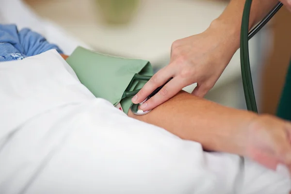 Enfermeira que mede a pressão arterial — Fotografia de Stock
