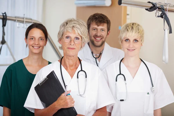Equipo de médicos sonriendo juntos en la clínica —  Fotos de Stock