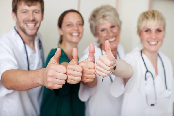 Equipo de médicos felices mostrando pulgares hacia arriba — Foto de Stock
