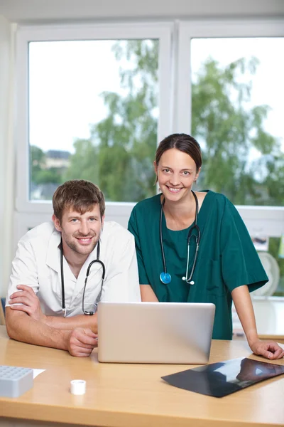 Läkare med laptop lutar på skrivbord — Stockfoto